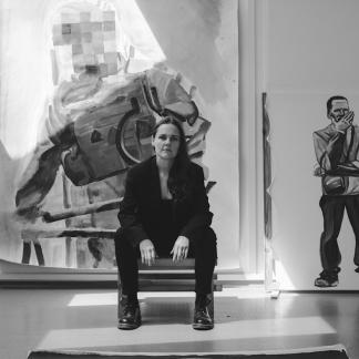 Woman sitting in front of a painting
